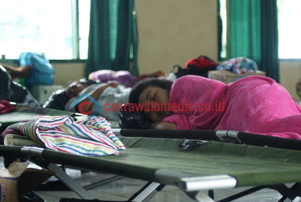 Seorang pengungsi tertidur lelap di atas veldbed tentara.