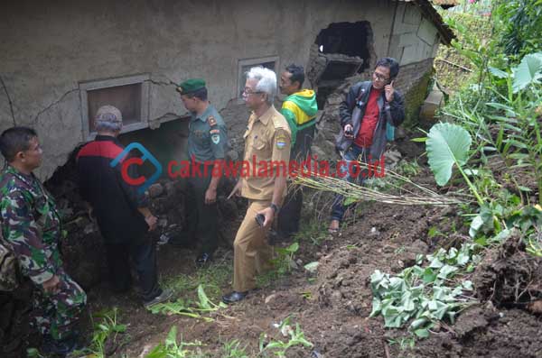 Sejumlah aparat TNI dan Kecamatan Singaparna saat melihat kondisi rumah Udin yang nyaris roboh diterjang longsoran tanah pada Selasa ( 18/10 ).